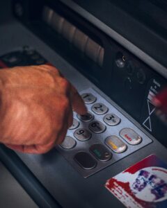Hand pressing keypad of an ATM in Brazil, emphasizing modern banking technology.